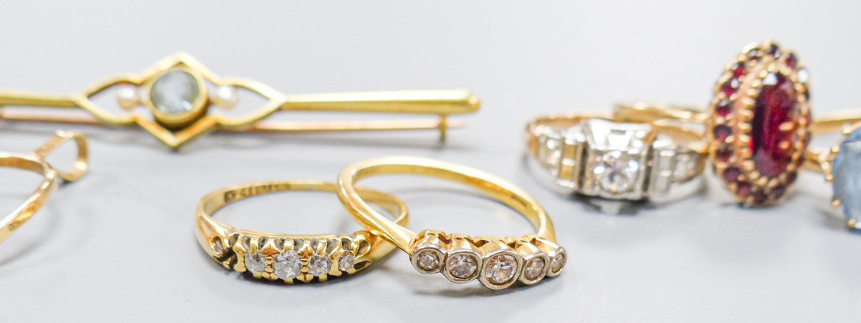 Three 18ct gold and gem set rings including two five stone half hoop(one stone missing) and a sapphire and diamond three stone, gross weight 7.3 grams, four 9ct and gem set rings and a 9ct pendant, gross 11.8 grams, a 15